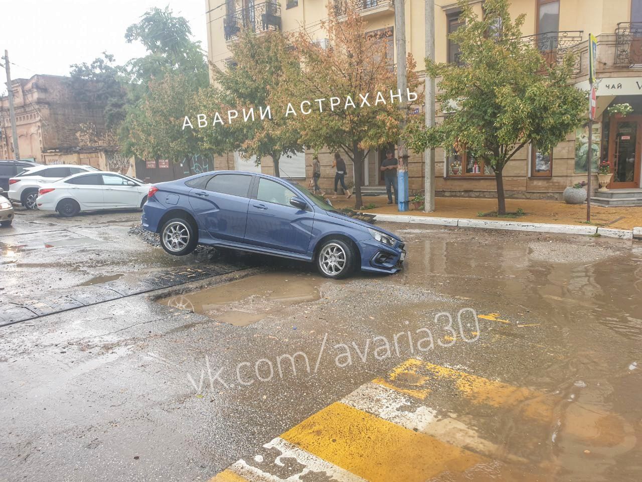 В центре Астрахани после дождя машина провалилась в яму в асфальте